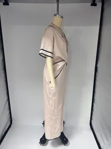 Vue de côté d'une robe d'été bohème élégante rose avec des bordures noires fines.