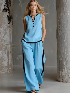 Elegant detail of a blue sleeveless top and wide-leg trousers set featuring black contrast piping