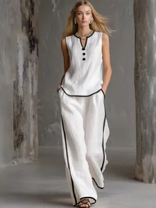 Model wearing a stylish white sleeveless top and wide-leg trousers two-piece set with black trim