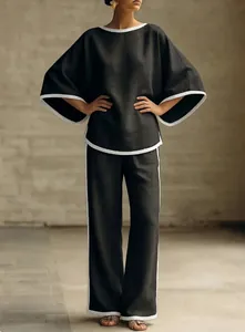 Full view of elegant black cotton linen set with white piping and batwing sleeves