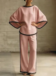 Detailed view of elegant pink linen two-piece set featuring batwing sleeves and black trim