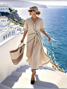 Robe longue bohème élégante beige avec liserés noirs et détail torsadé à la taille pour l'été.