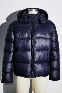 Close-up detail of women's navy blue hooded puffer jacket with metallic sheen finish