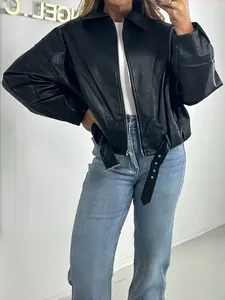 Close-up detail of the vintage black faux leather aviator jacket showing the belted hem
