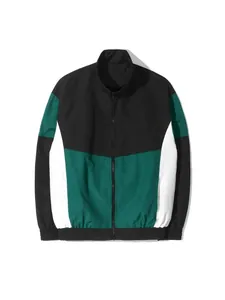 Vista detallada de un cortavientos con diseño de bloques en negro, verde y blanco.