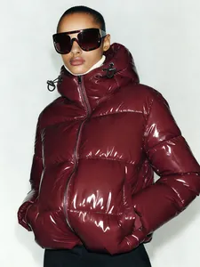 Close-up detail of premium burgundy glossy hooded puffer jacket for women winter