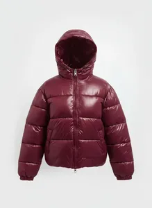 Detailed macro view of a shiny burgundy hooded puffer jacket featuring quilted padding