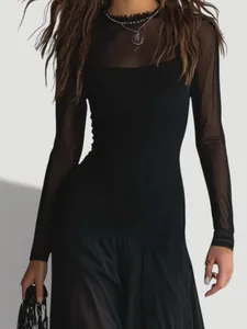 Dettaglio di un elegante abito nero con maniche e scollo in rete trasparente.