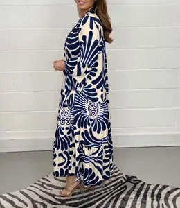 Vista lateral de un vestido largo holgado con estampado floral azul en crema
