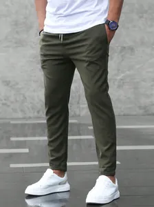Detail view of men's army green joggers featuring a drawstring waist and tapered fit