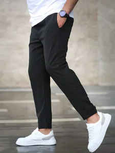 Side view of man wearing black slim-fit cropped casual pants and white sneakers