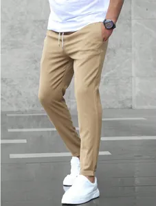 Macro detail of khaki men's drawstring business joggers with slim tapered fit style