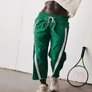 Grüne Sporthose mit hoher Taille, weitem Bein, weißen Seitenstreifen und bequemem Kordelzug