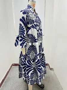 Vista lateral de un vestido maxi escalonado con estampado azul y blanco y mangas con volantes.