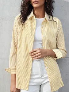 Detail shot of a women's yellow and white striped long-sleeve shirt in a casual chic style