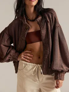 Detailed view of women's oversized brown knitted cardigan with retro lantern sleeves.