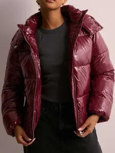 Primer plano detallado de una chaqueta acolchada con capucha burdeos brillante para mujer