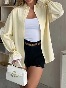 Elegant yellow striped women's shirt with flared lace cuffs and chic long sleeves