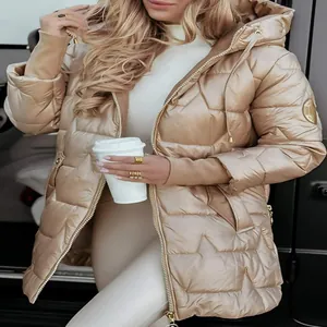 Detailed view of women's gold puffer jacket featuring unique star quilted pattern