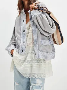 Detailed view of women's loose light blue knit cardigan jacket with layered lace top