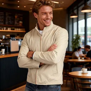Stylish men's stand collar zip jacket in light beige shown in a cozy cafe setting.