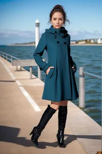 Detailweergave van een dames wollen jas in groenblauw met capuchon en een wijde zoomlijn