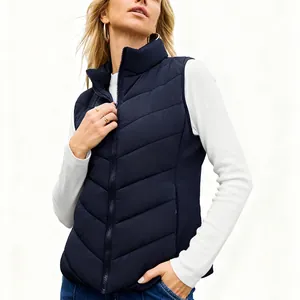 Detail shot of a navy blue chevron quilted puffer vest for women featuring stand collar