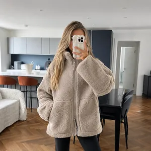 Gedetailleerd overzicht van een beige oversized sherpa fleecejack met hoge kraag en rits