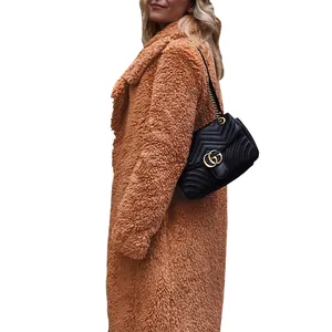 Side view of woman wearing cozy camel long teddy coat with soft lamb wool texture