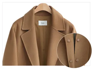 Macro view showing snap buttons and lapel detail on a long camel double-faced wool coat