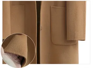 Close-up detail of premium camel wool coat showing soft fabric texture and pocket