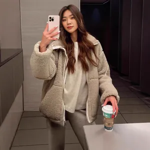 Aziatisch model in stijlvol beige lamswollen fleecejack met koffie in spiegelselfie