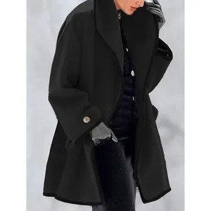 Détail d'un manteau en laine noir ample pour femme avec bouton de manchette