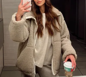 Lifestyle spiegelselfie die de textuur en pasvorm van de beige sherpa fleece jas toont