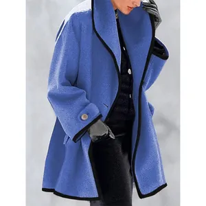 Gros plan d'un manteau en laine bleue avec d'élégants liserés noirs contrastés et coupe ample.
