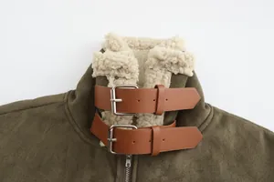 Detailed view of faux suede shearling jacket collar with brown leather buckles.