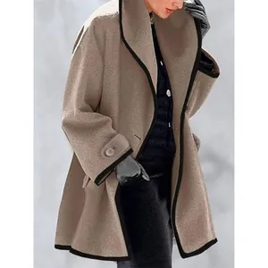 Détail d'un manteau d'automne en laine beige coupe large avec bordure noire contrastée.