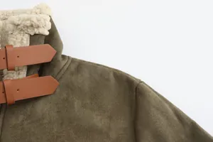 Close-up of men's faux suede coat collar showing shearling lining and leather buckle straps