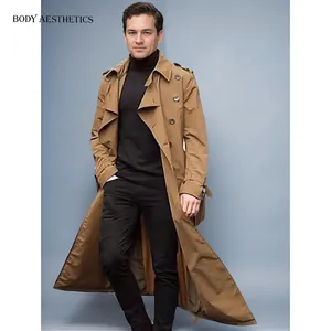 Mann in klassischem braunem extralangem Trenchcoat über schwarzem Rollkragenpullover.