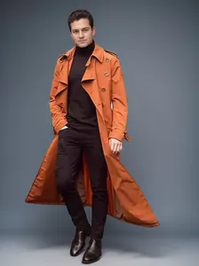 Männliches Model in einem stylischen orangen langen Trenchcoat für modische Herren