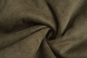 Detailed macro view showing the soft texture of premium brown faux suede fabric for winter coats