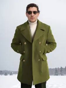 Fashionable man wearing olive green double-breasted woolen coat in a snowy outdoor setting