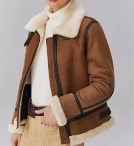 Close-up van een bruine lammy coat met witte bontkraag en zwarte leren biesdetails.
