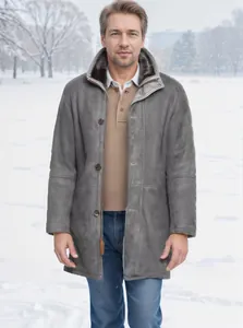 Front view of man in grey mid-length sheepskin coat with fur collar on snowy background