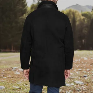 Rear view of a men's black mid-length faux shearling-lined coat in an outdoor setting
