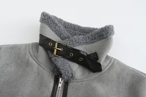 Macrodetail van grijze faux lamswollen jaskraag met een zwarte leren riemgespsluiting