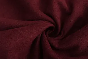 Gedetailleerde macrotextuurweergave van premium bordeauxrood imitatiesuède voor herenjassen