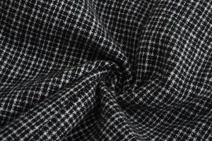 Dettaglio della trama del tessuto pied-de-poule bianco e nero per blazer maschile