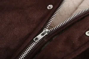 Macro-detail van metalen rits en warme fleecevoering op een bruin suède herenjack
