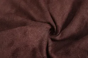 Gedetailleerde macro-weergave van de zachte textuur en bruine kleur van de faux suède stof.